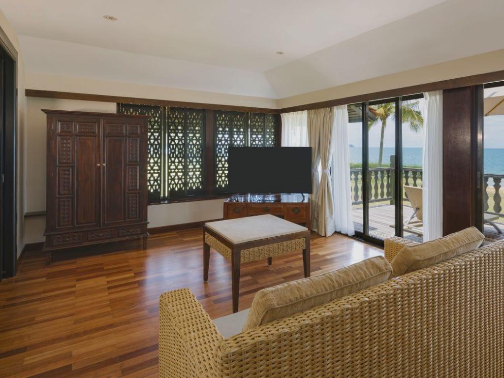 Luxury Club Med Cherating Suite bedroom opening up to a private wooden seaside terrace with outdoor seating